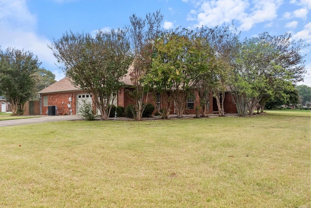 view of property hidden behind natural elements with a front yard and a garage