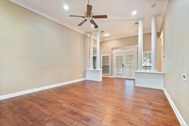 unfurnished living room with wood-type flooring, ornate columns, ceiling fan, and crown molding