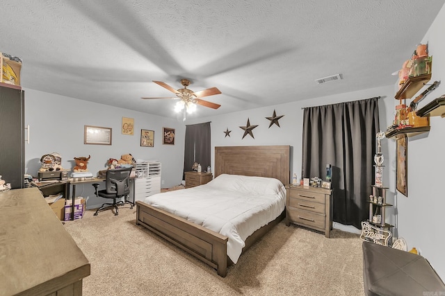 carpeted bedroom featuring a textured ceiling and ceiling fan