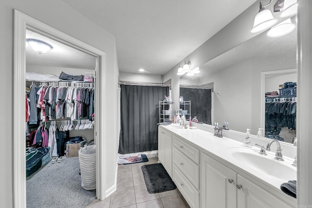 bathroom with tile patterned flooring, vanity, a textured ceiling, and walk in shower