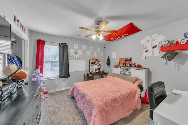 carpeted bedroom featuring ceiling fan and a textured ceiling