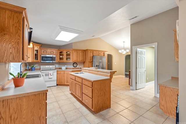 kitchen with a center island, lofted ceiling, sink, appliances with stainless steel finishes, and light tile patterned flooring