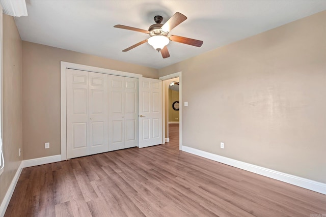 unfurnished bedroom with light wood-type flooring, a closet, and ceiling fan