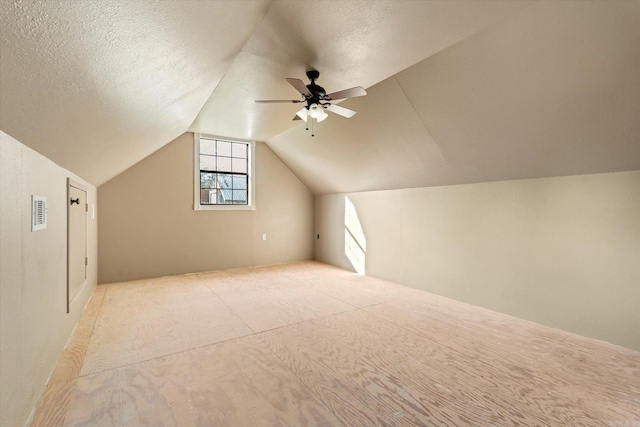 bonus room with a textured ceiling, vaulted ceiling, and ceiling fan