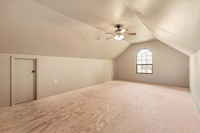 bonus room featuring a textured ceiling, vaulted ceiling, and ceiling fan