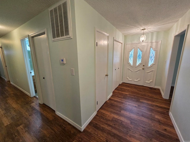 foyer with a textured ceiling and dark hardwood / wood-style flooring