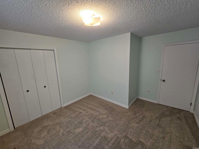 unfurnished bedroom with a textured ceiling, carpet floors, and a closet