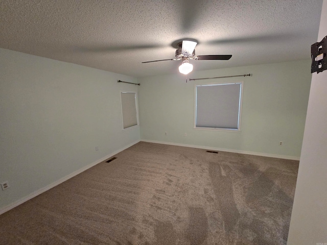 carpeted spare room featuring ceiling fan and a textured ceiling