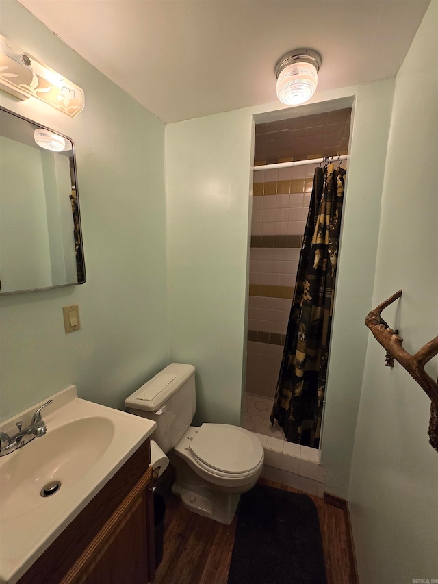 bathroom with wood-type flooring, vanity, toilet, and walk in shower