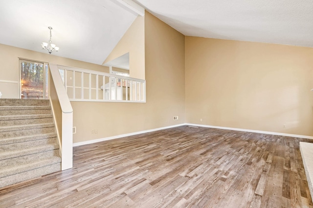 unfurnished living room featuring beamed ceiling, light wood-type flooring, high vaulted ceiling, and a chandelier