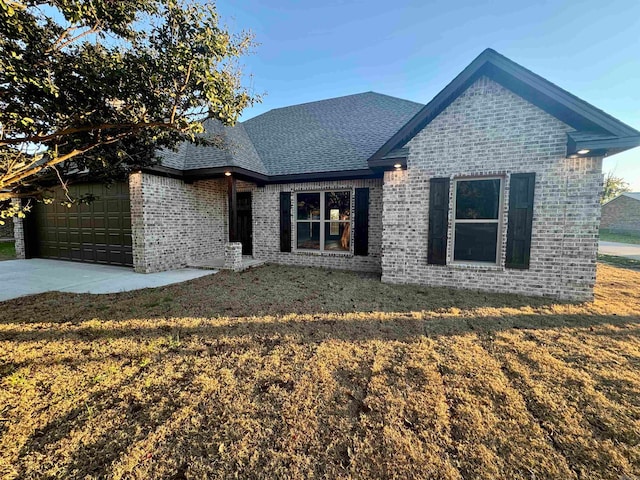 view of front of property with a garage and a front lawn