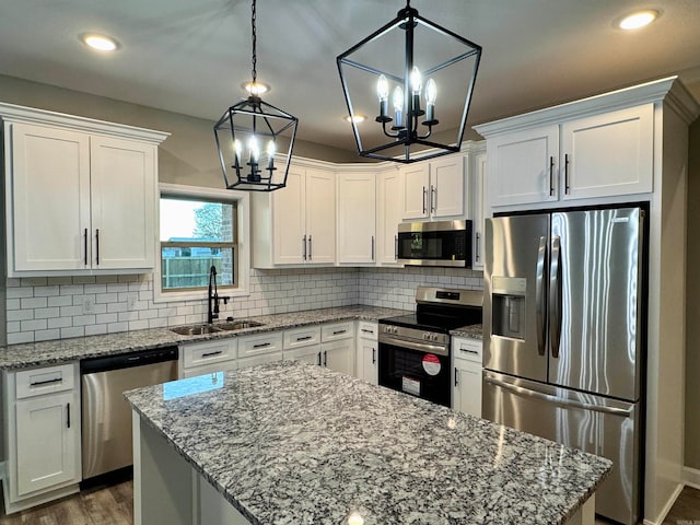 kitchen featuring white cabinetry, hanging light fixtures, and appliances with stainless steel finishes