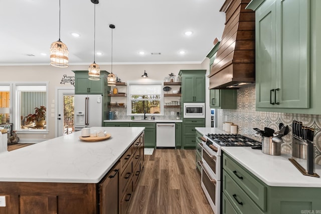 kitchen featuring white appliances, green cabinetry, dark hardwood / wood-style floors, a kitchen island, and hanging light fixtures