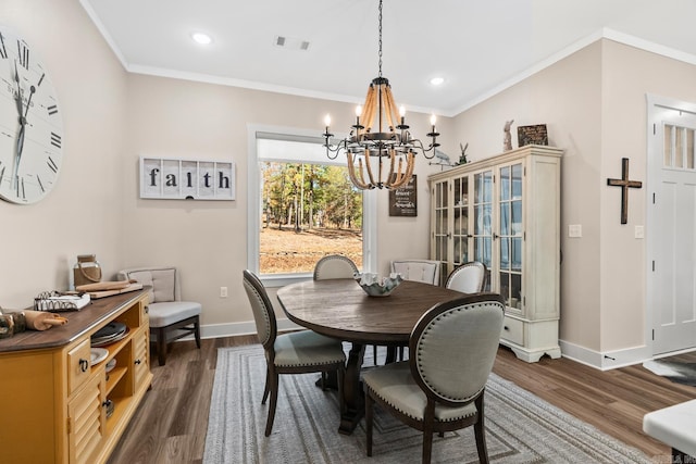 dining area featuring dark hardwood / wood-style flooring, crown molding, and a chandelier