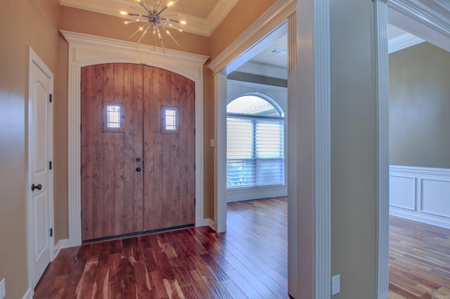 entrance foyer featuring crown molding, dark hardwood / wood-style flooring, and a notable chandelier