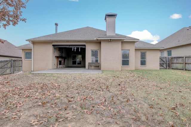 back of property featuring a patio and a lawn