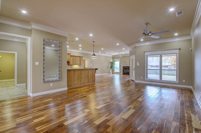 unfurnished living room with crown molding, ceiling fan, and wood-type flooring