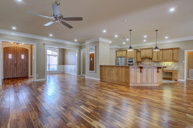 unfurnished living room featuring hardwood / wood-style floors, ceiling fan, and ornamental molding