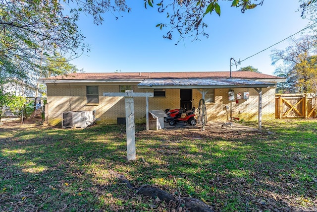 rear view of house with a lawn and central air condition unit