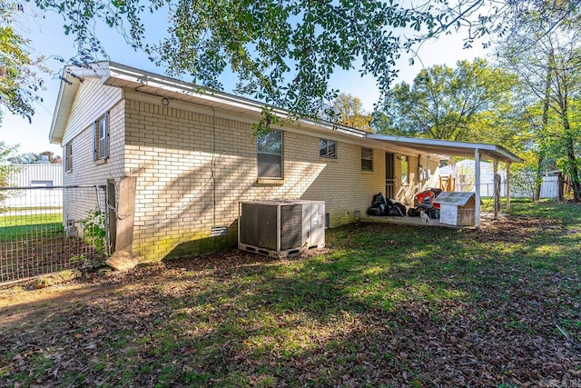 back of property featuring a lawn and central AC unit