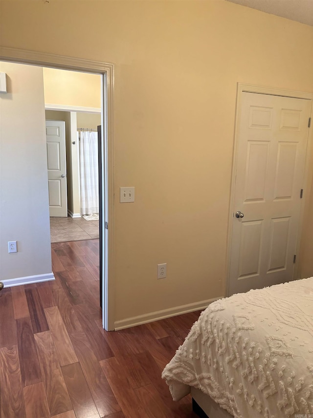 bedroom with dark hardwood / wood-style flooring