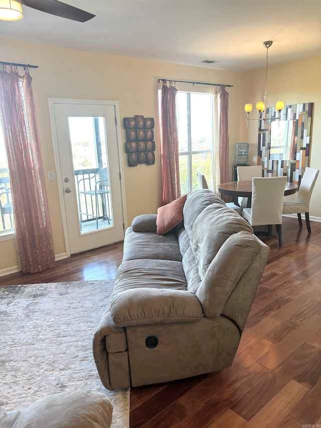 living room with wood-type flooring and ceiling fan with notable chandelier