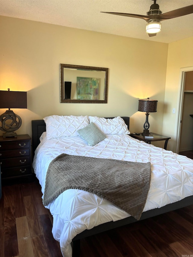 bedroom with a textured ceiling, dark hardwood / wood-style floors, and ceiling fan