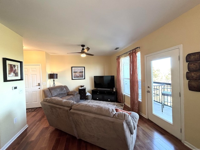 living room featuring ceiling fan and dark wood-type flooring