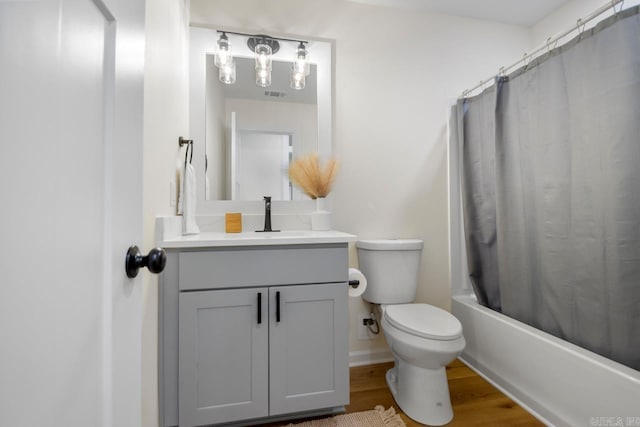 full bathroom featuring vanity, hardwood / wood-style flooring, toilet, and shower / bath combo with shower curtain