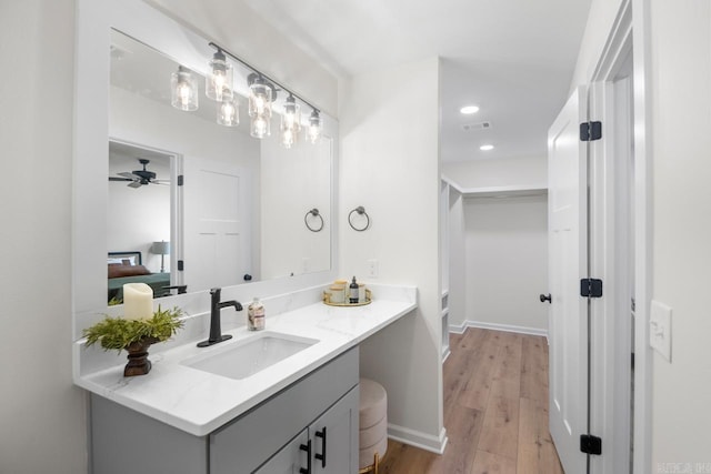 bathroom featuring vanity, ceiling fan, and wood-type flooring