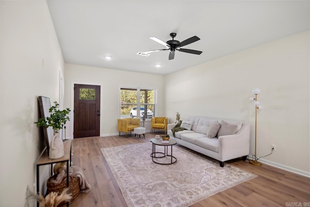 living room featuring ceiling fan and light hardwood / wood-style floors