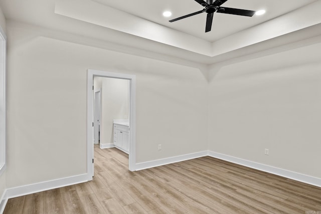 empty room with ceiling fan and light hardwood / wood-style flooring