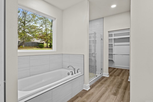 bathroom featuring hardwood / wood-style flooring and separate shower and tub