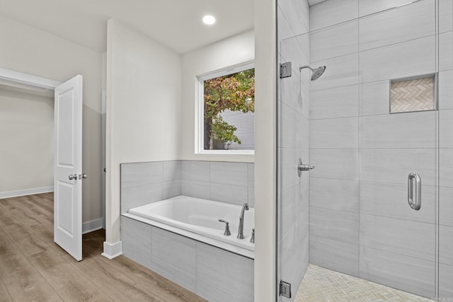 bathroom featuring hardwood / wood-style floors and independent shower and bath