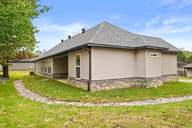 view of property exterior with central AC unit and a yard