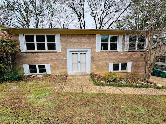 raised ranch featuring a front yard and french doors