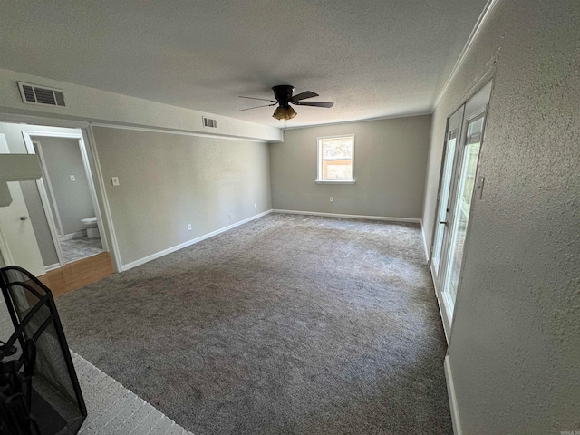 carpeted spare room with ceiling fan and a textured ceiling