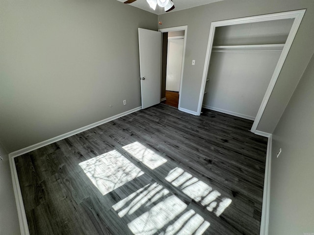 unfurnished bedroom featuring dark hardwood / wood-style flooring, ceiling fan, and a closet