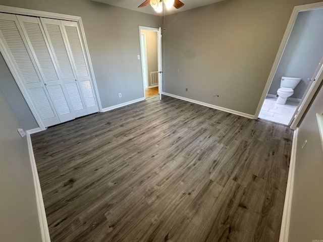 unfurnished bedroom featuring a closet, ceiling fan, dark hardwood / wood-style flooring, and ensuite bathroom