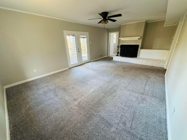 unfurnished living room with ceiling fan, french doors, a brick fireplace, crown molding, and carpet floors