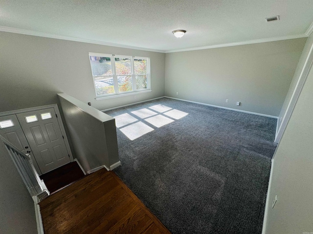 interior space with crown molding, dark carpet, and a textured ceiling