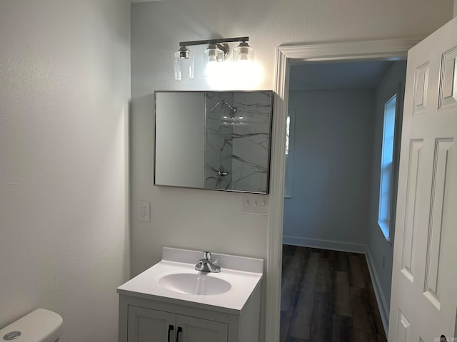 bathroom with hardwood / wood-style floors, vanity, and toilet