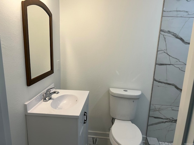 bathroom featuring vanity, toilet, and tiled shower