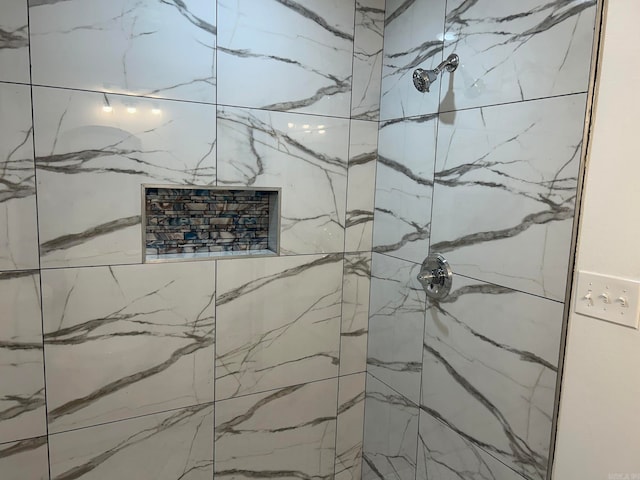 interior details featuring tiled shower