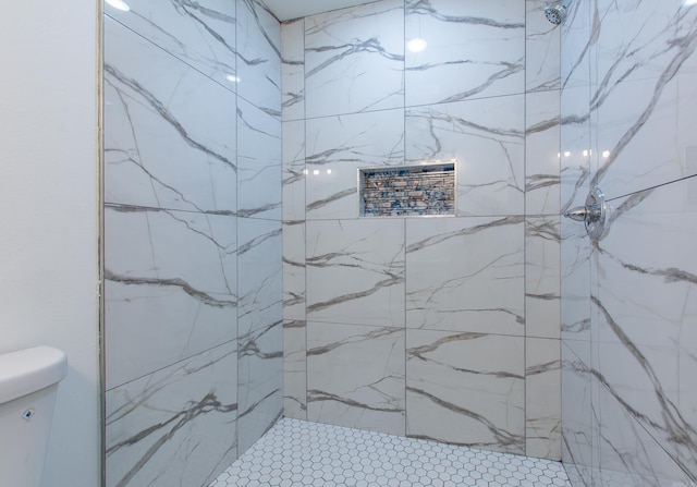 bathroom featuring toilet and a tile shower