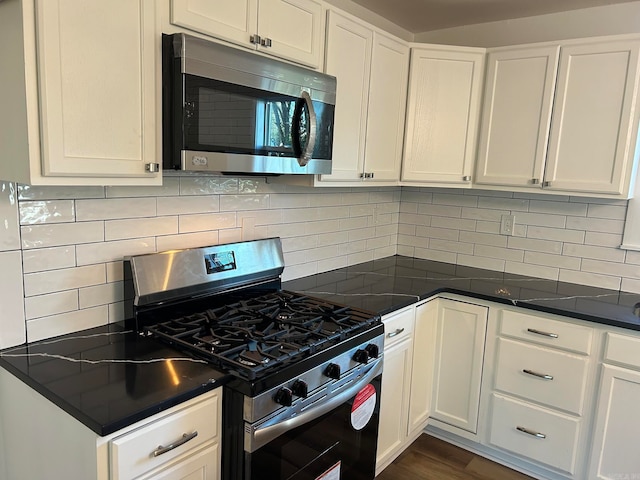 kitchen featuring white cabinets, decorative backsplash, stainless steel appliances, and dark hardwood / wood-style floors