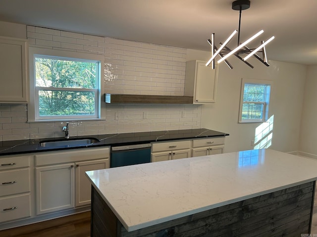 kitchen featuring dishwasher, pendant lighting, tasteful backsplash, and sink