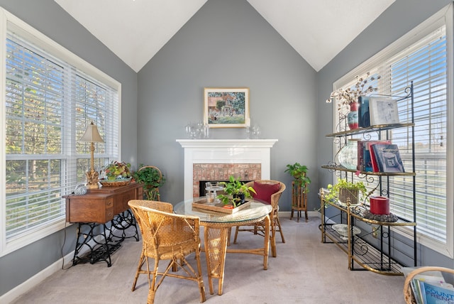 sitting room with light colored carpet, lofted ceiling, and a brick fireplace