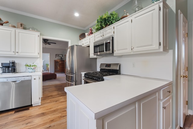 kitchen featuring ornamental molding, white cabinets, light hardwood / wood-style floors, and appliances with stainless steel finishes