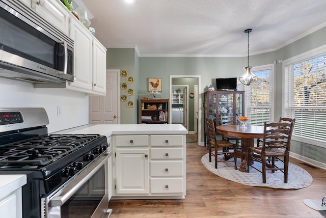 kitchen featuring light wood-type flooring, stainless steel appliances, and white cabinetry